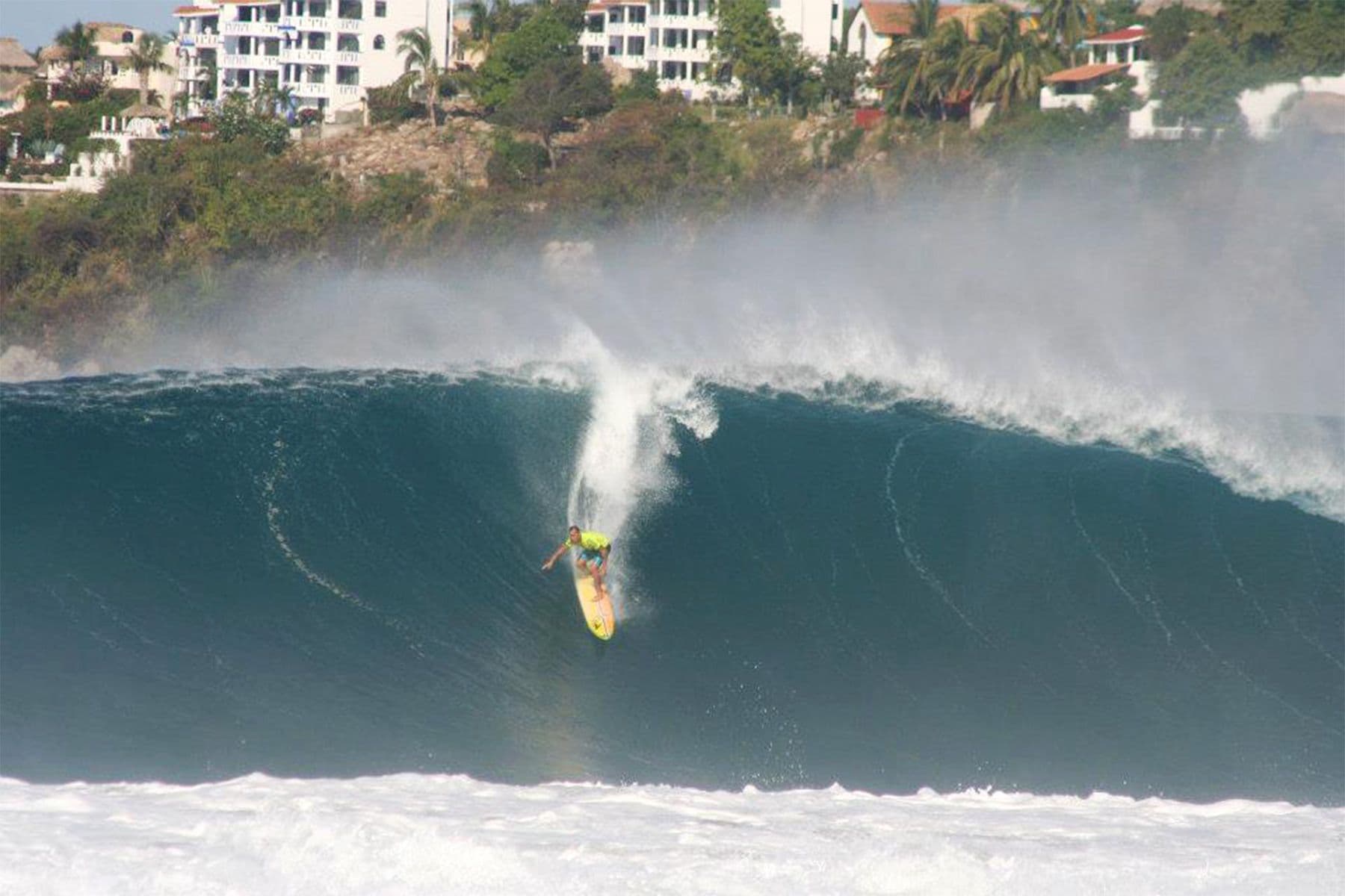 surfer dropping into a big wave at puerto escondido in mexico