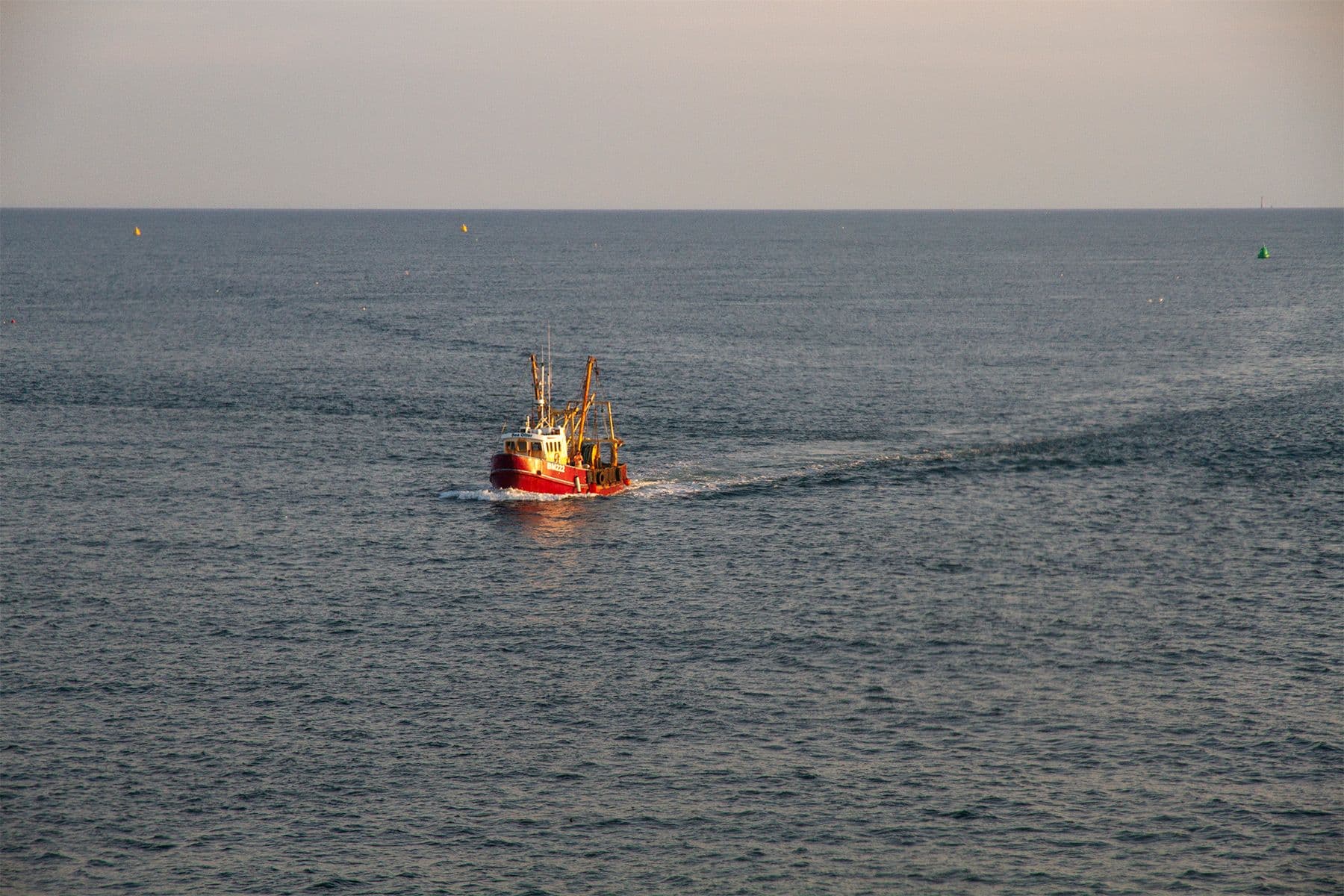 fishing boat returning to port at sunset