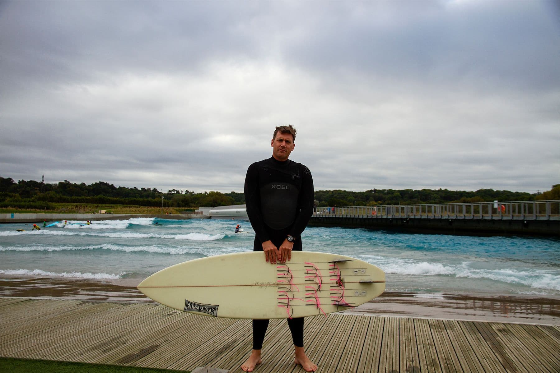 harry knight, director of coaching at surf simply, at the wave inland surf destination in bristol with a surfboard covered in tell tales for an experiment into water flow