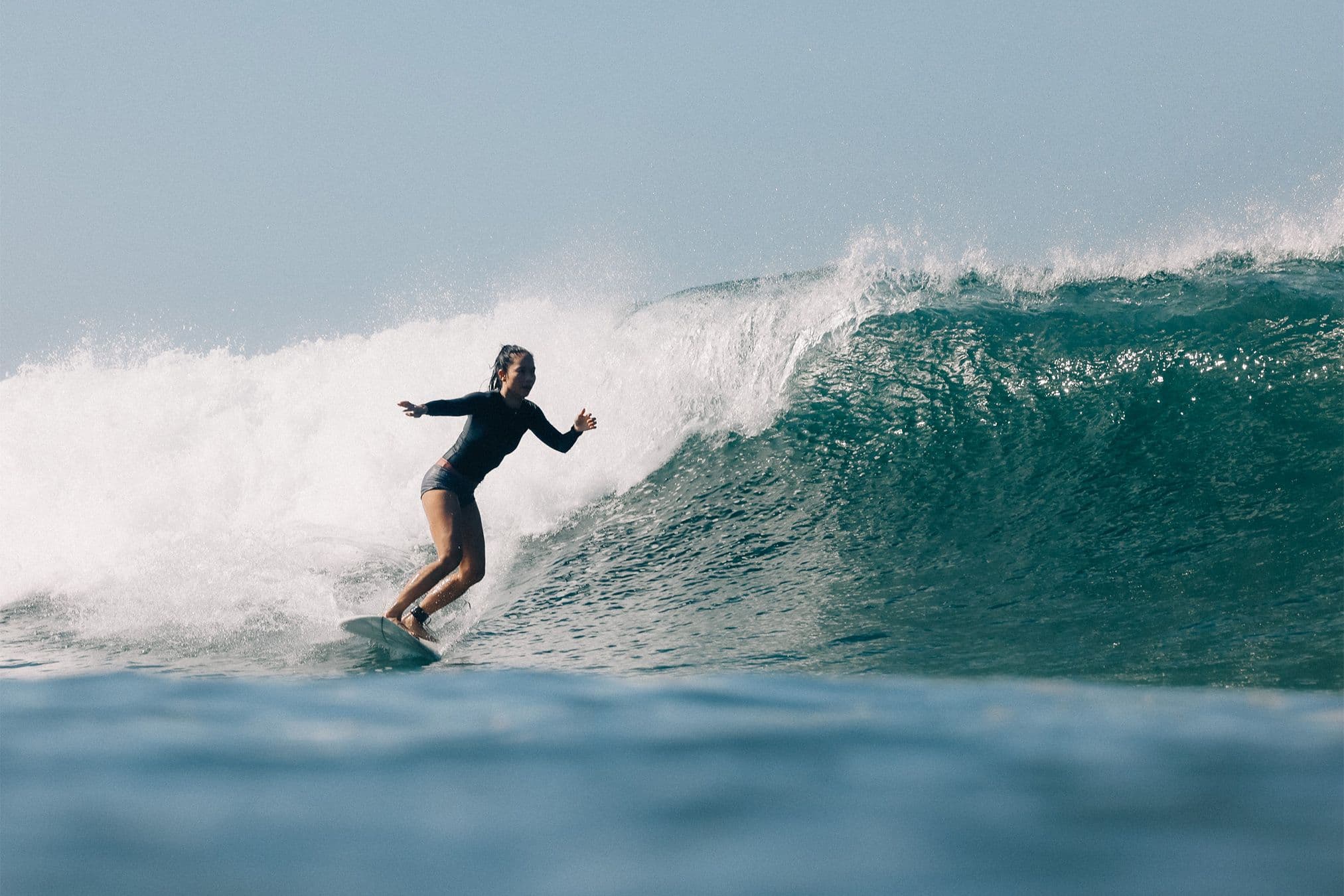 bonnie tsui about to bottom turn on a head high wave in costa rica