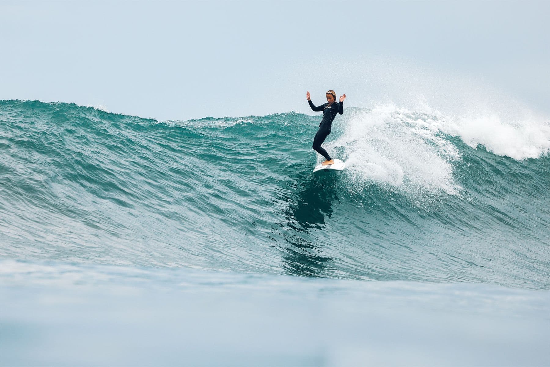 woman stylishly riding a large wave in costa rica
