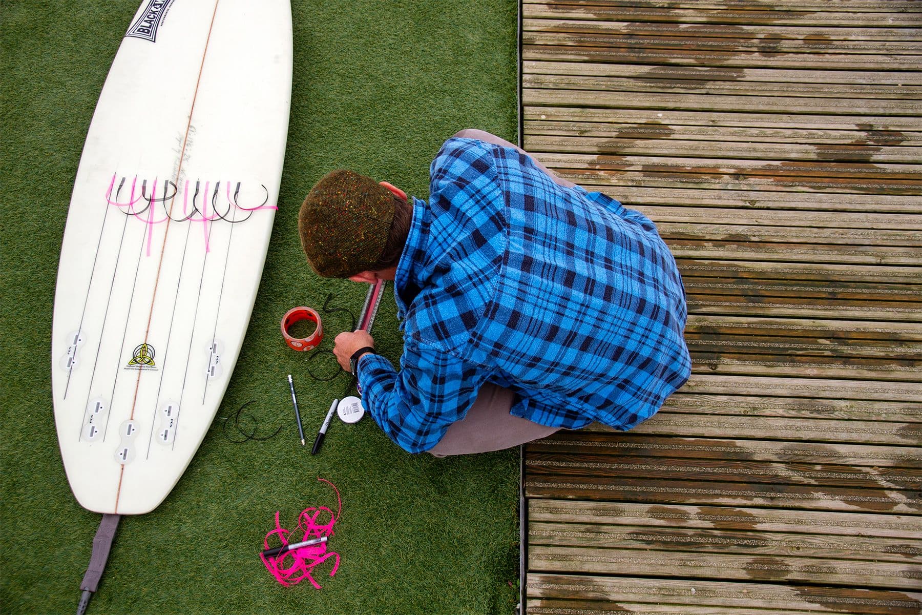surf simply director of coaching harry knight sticking multicoloured telltale ribbons to the bottom of his surfboard for an experiment